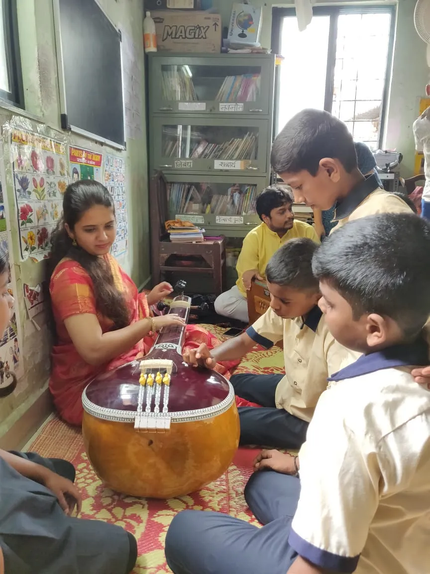 Curious children playing Tanpura.DevY0wbX